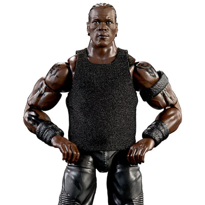 A muscular male action figure or collectible character posed with hands on hips, wearing a black sleeveless textured top, black pants, and black wrist wraps, photographed against a plain white background.
